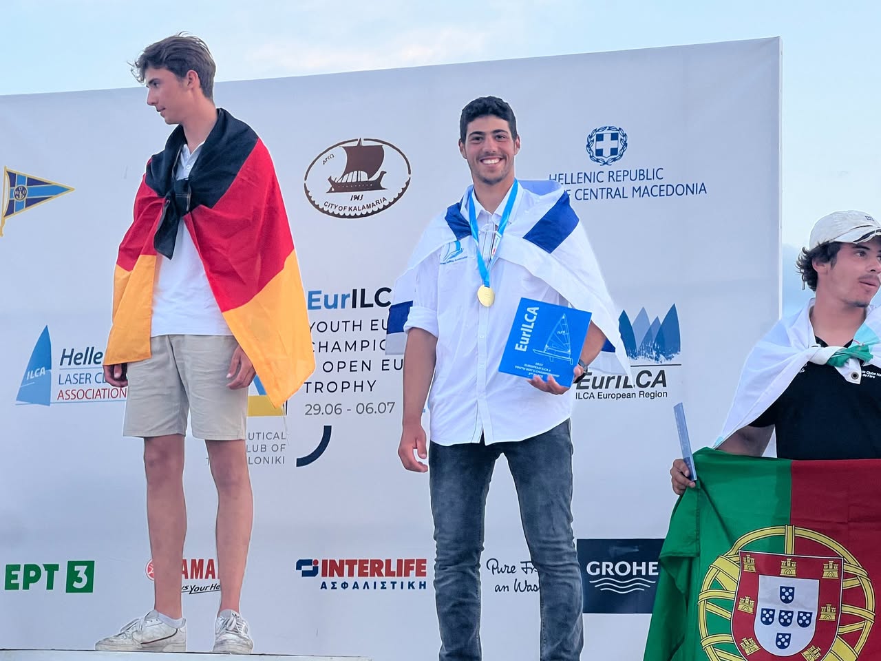 Yogev Alcalay on the podium wearing an Israeli flag and gold medal